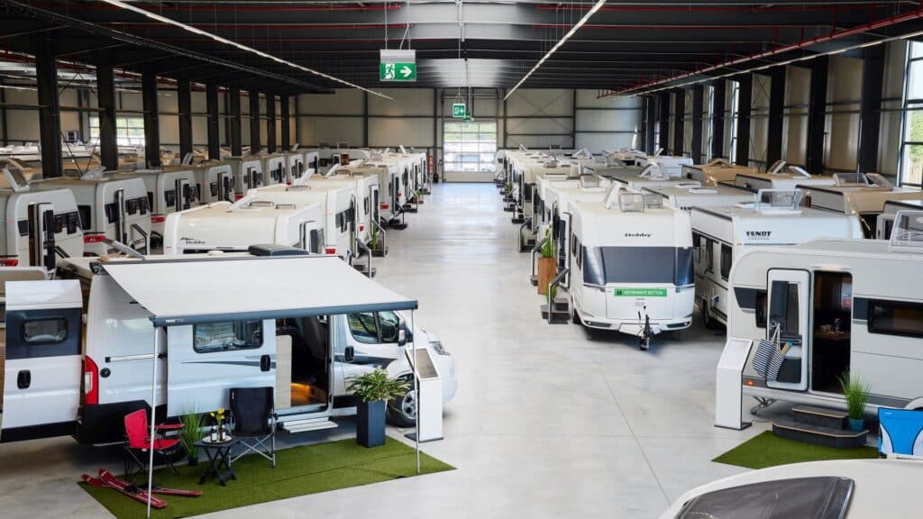 Innenansicht der Ausstellungshalle im Caravan Center Bocholt mit zahlreichen Wohnmobilen und Wohnwagen.