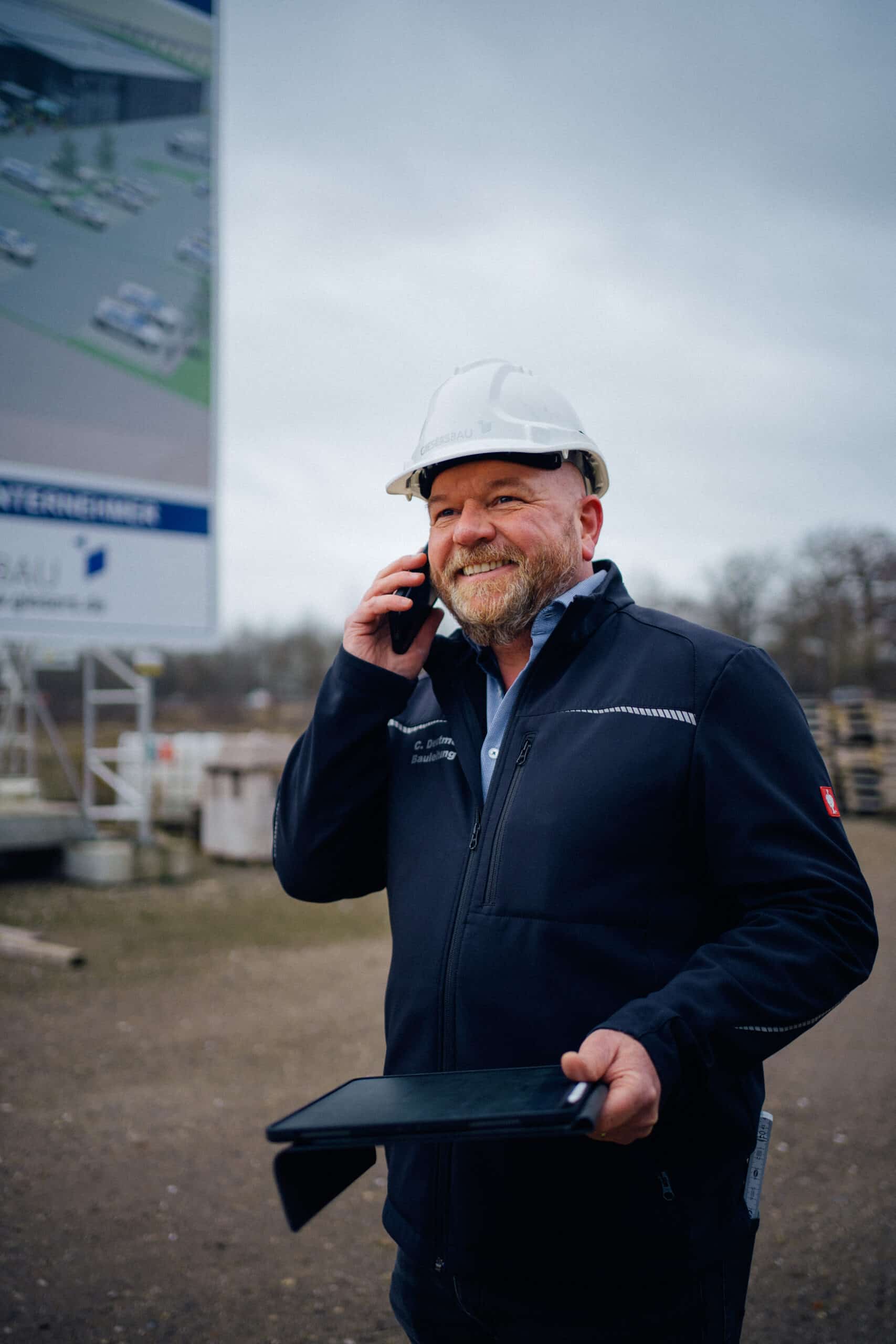 Giesers Bau Bauleiter telefonierend auf der Baustelle